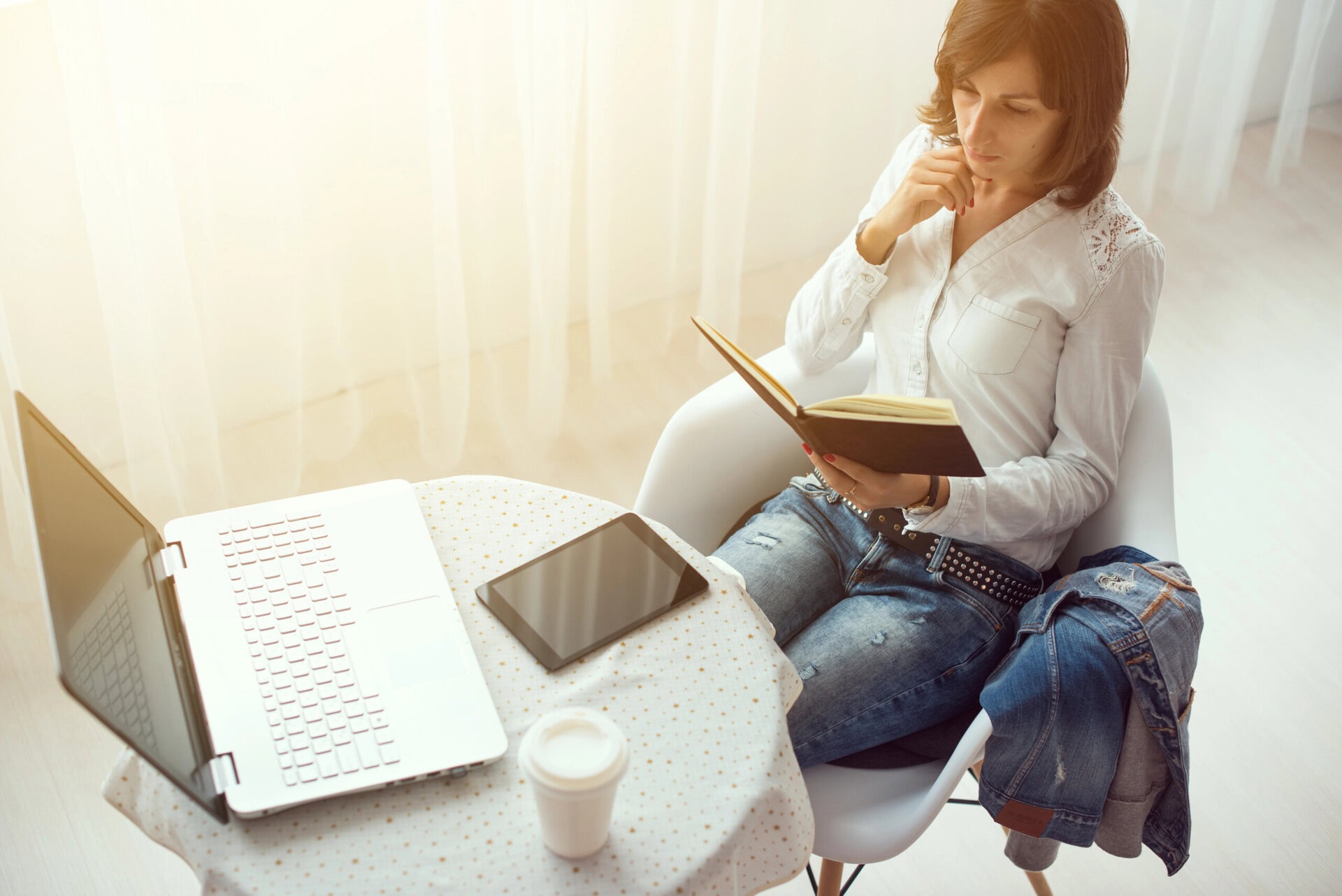Businesswoman with laptop and diary in a bright office